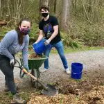 two adults volunteering by a natural trail
