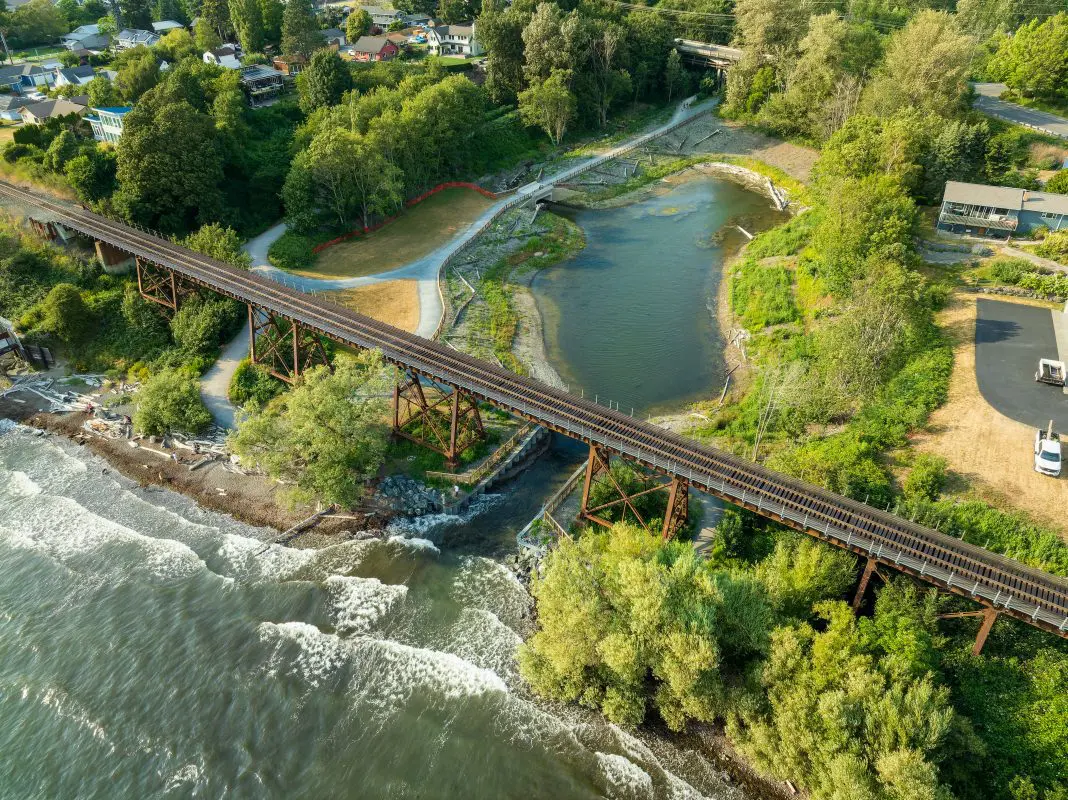 Aerial view of estuary with water in it with a railroad trestle going over it 