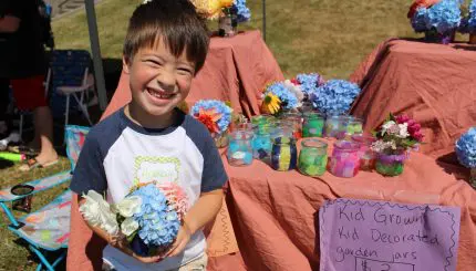 Young boy smiles while holding a garden pot