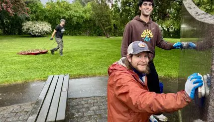 Two people clean a monument.