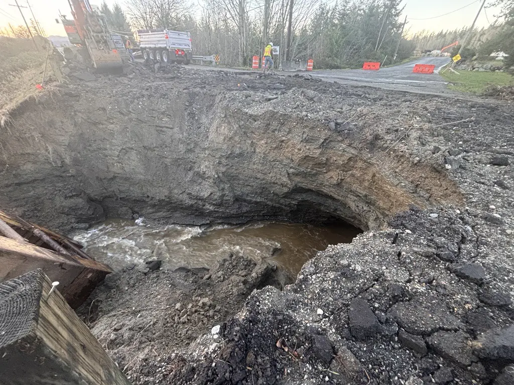 Extensive roadway damage and construction where a creek crosses under road