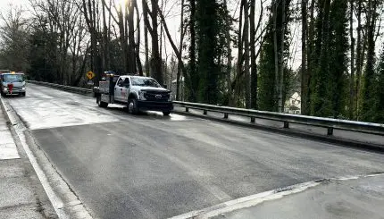 Recently repaired roadway with fresh section of asphalt