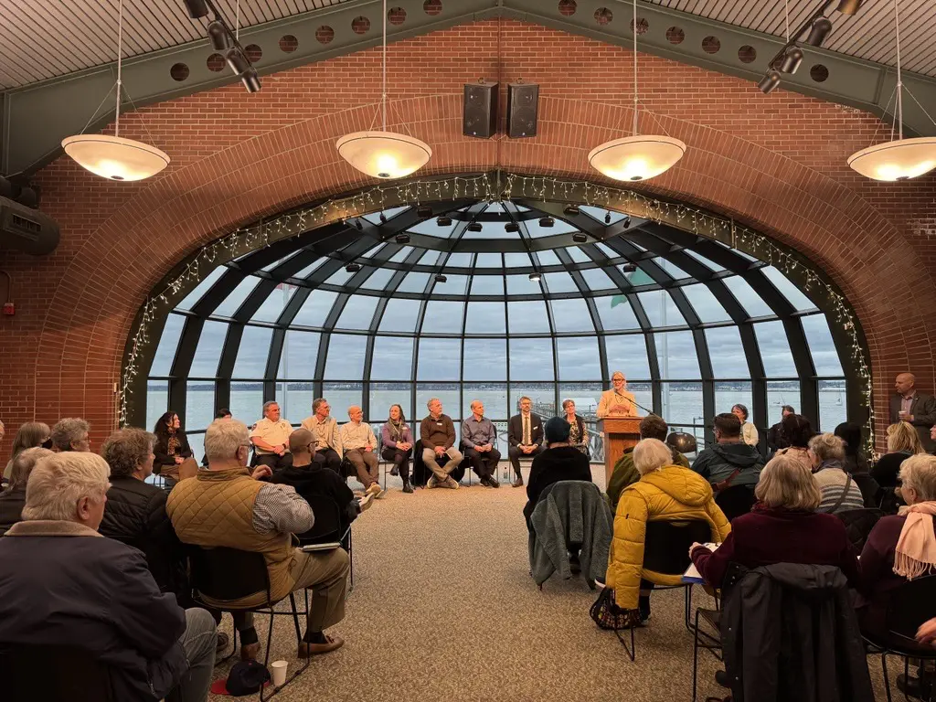 A crowd watches a group of panelists.