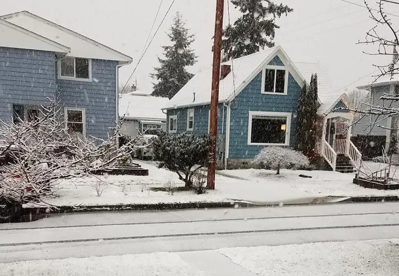 Residential street with snow on sidewalks and roads