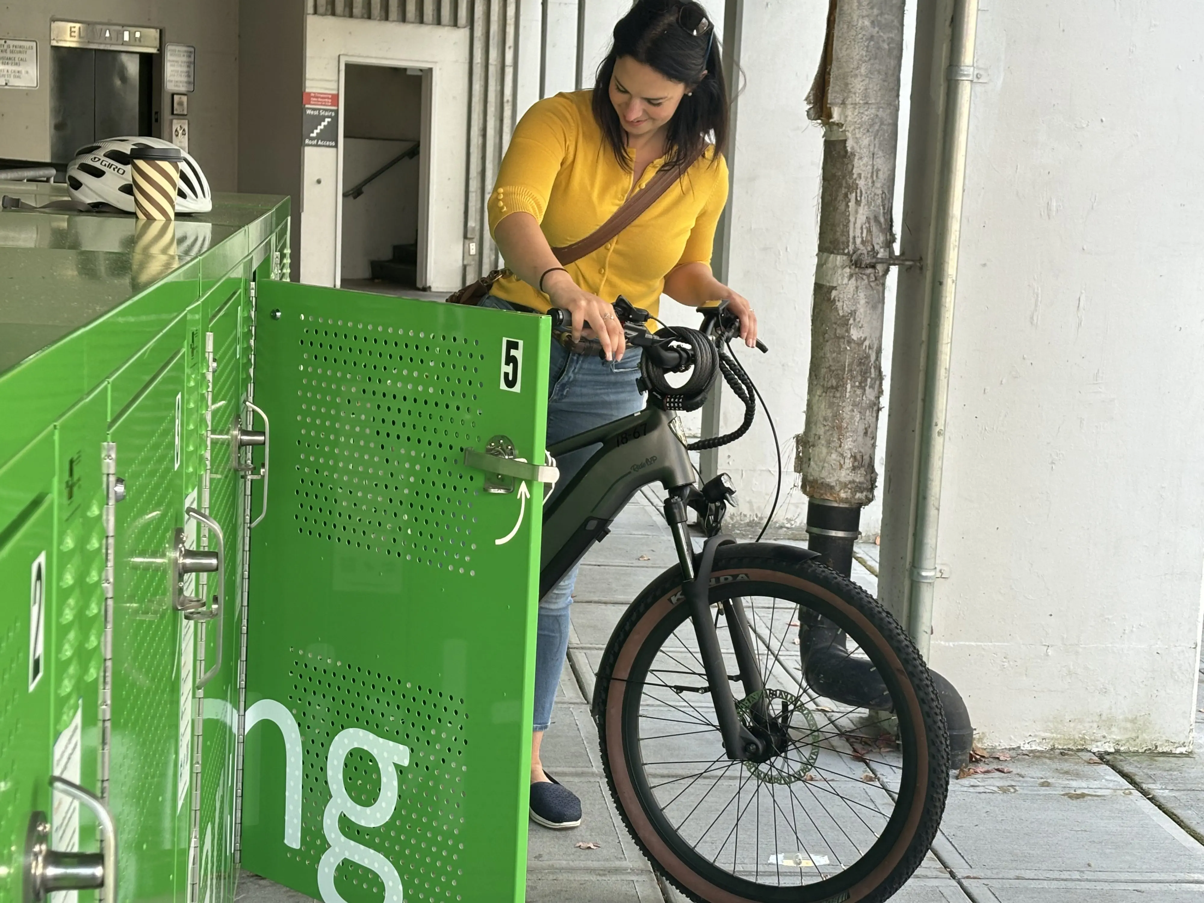 A woman puts a bicycle into a locker