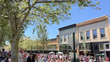 A crowded city street of soccer fans watching a match