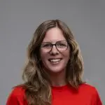 Professional headshot of a white woman in a red shirt