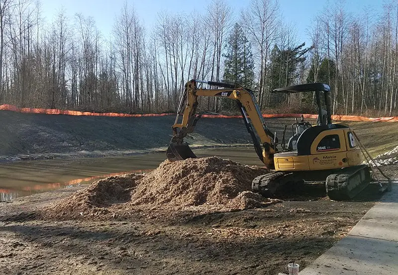 Excavator moving mulch