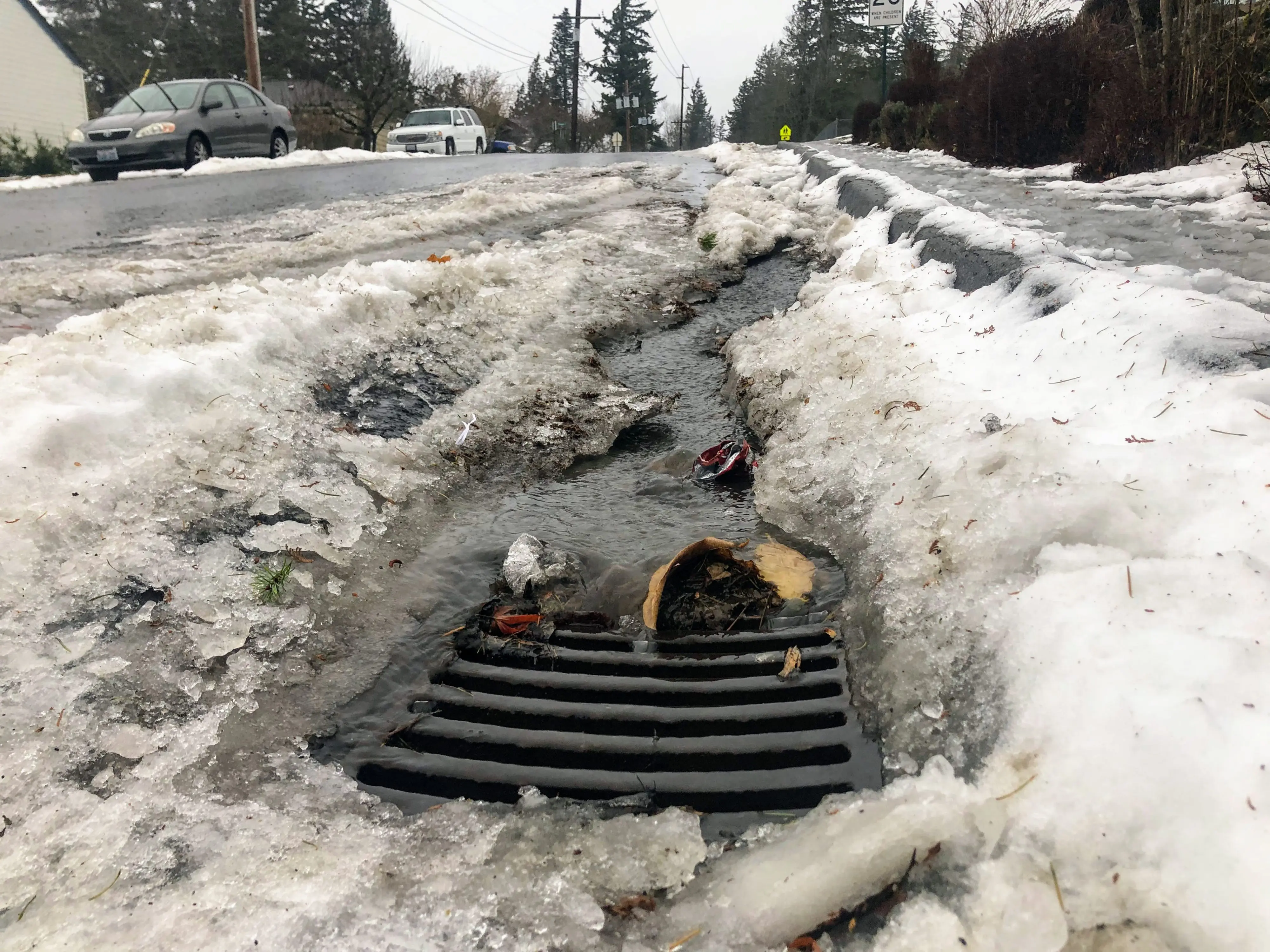 storm grate with slushy snow and runoff