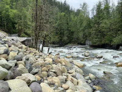 Flowing river. Partially removed dam visible in background.