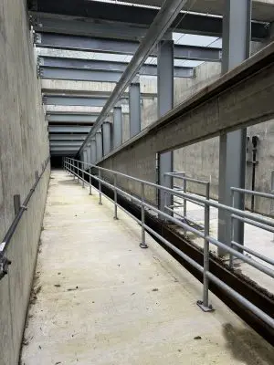 Inside fish screen structure. Screens can be seen above with a railing and walkway below.