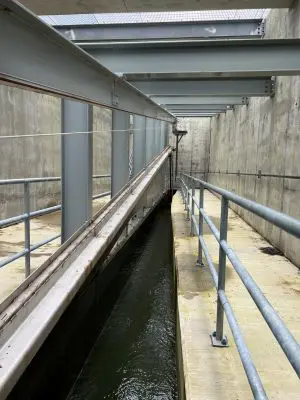 Inside fish screen structure. Water flowing in between two railings.