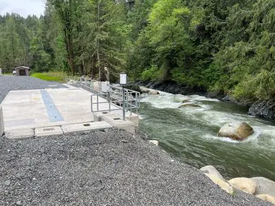 River flows alongside cement intake structure.