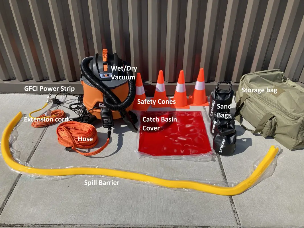 Photo showing a spill barrier, pump accessory, wet/dry vacuum, traffic cones, catch basin cover, sand bags, garden hose, power strip, and extension cord. 