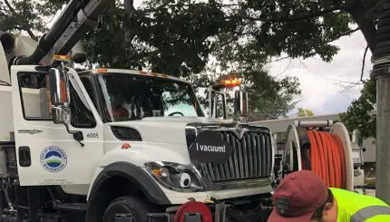 Small child talking with a Public Works employee in front of a parked big truck