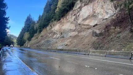 A freeway running next to a rocky slope