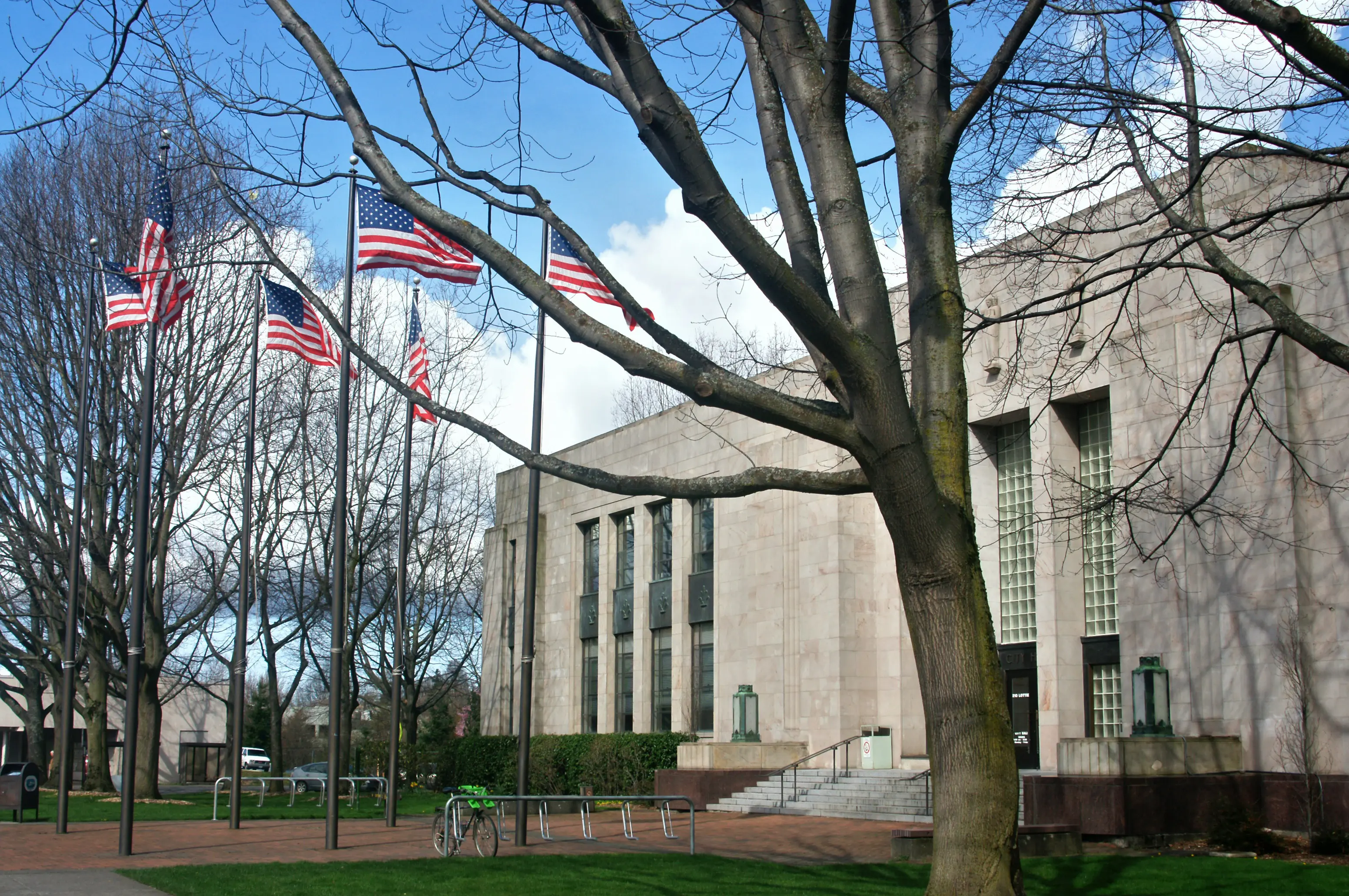 Bellingham City Hall and four American flags in the pavilion in front.