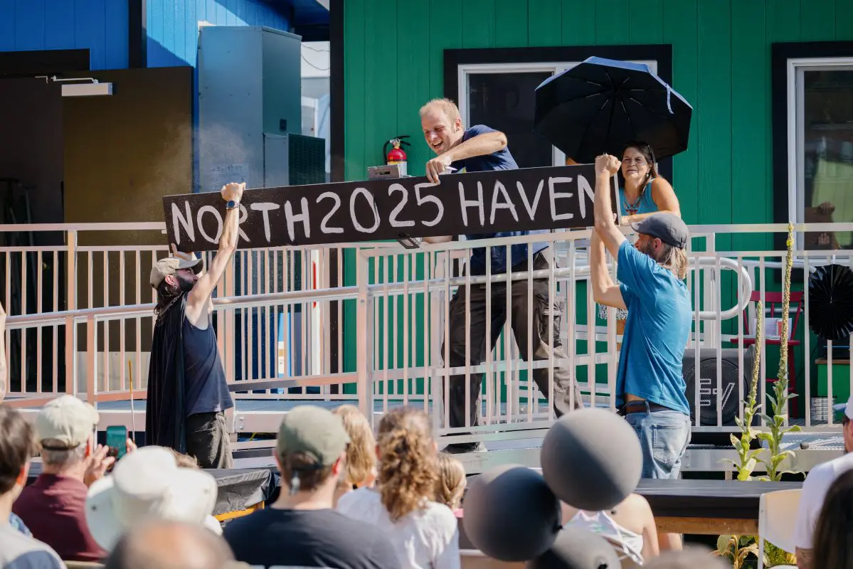 Several people cut through a wooden sign that says "North 2025 Haven"