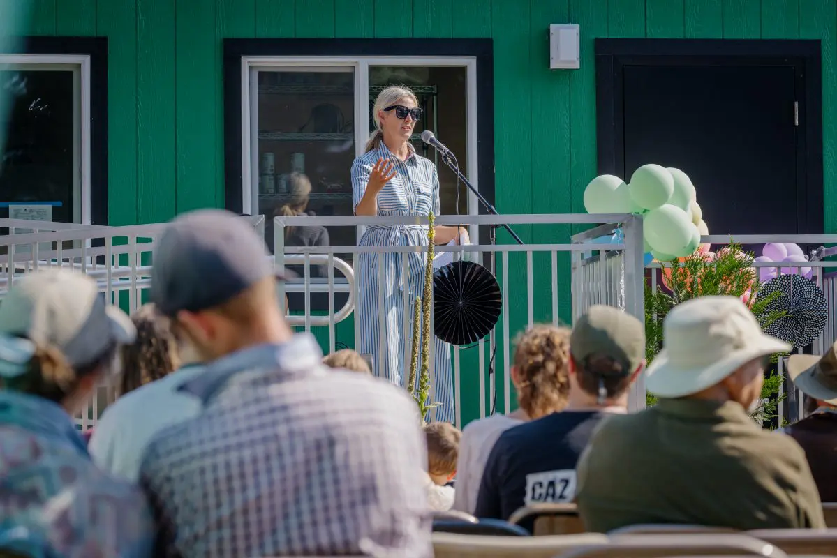A woman speaks from a platform