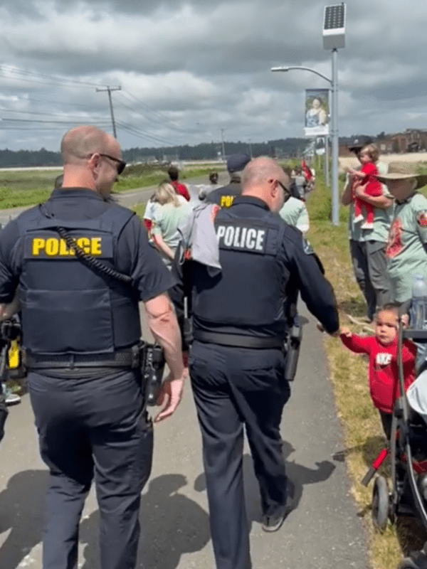 A police officer fist bumps a child at a walk