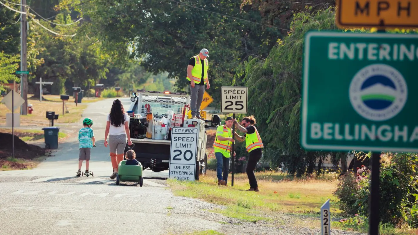 City crews install new 20 mph default speed limit sign at city entrance.