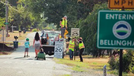 City crews install new 20 mph default speed limit sign at city entrance.