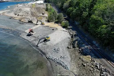 Excavators working on shoreline moving rocks around