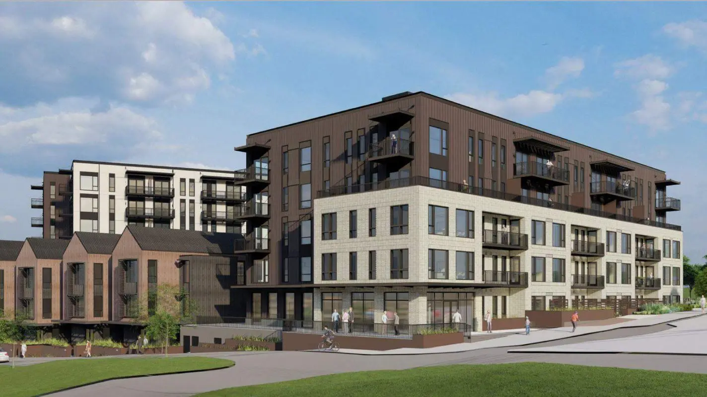 A rendering of a brown apartment building with townhomes in front of it