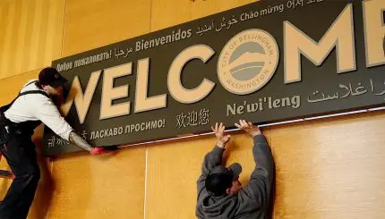 People install a sign that says "Welcome"