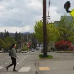 Person walking through hashed crosswalk with flashing light