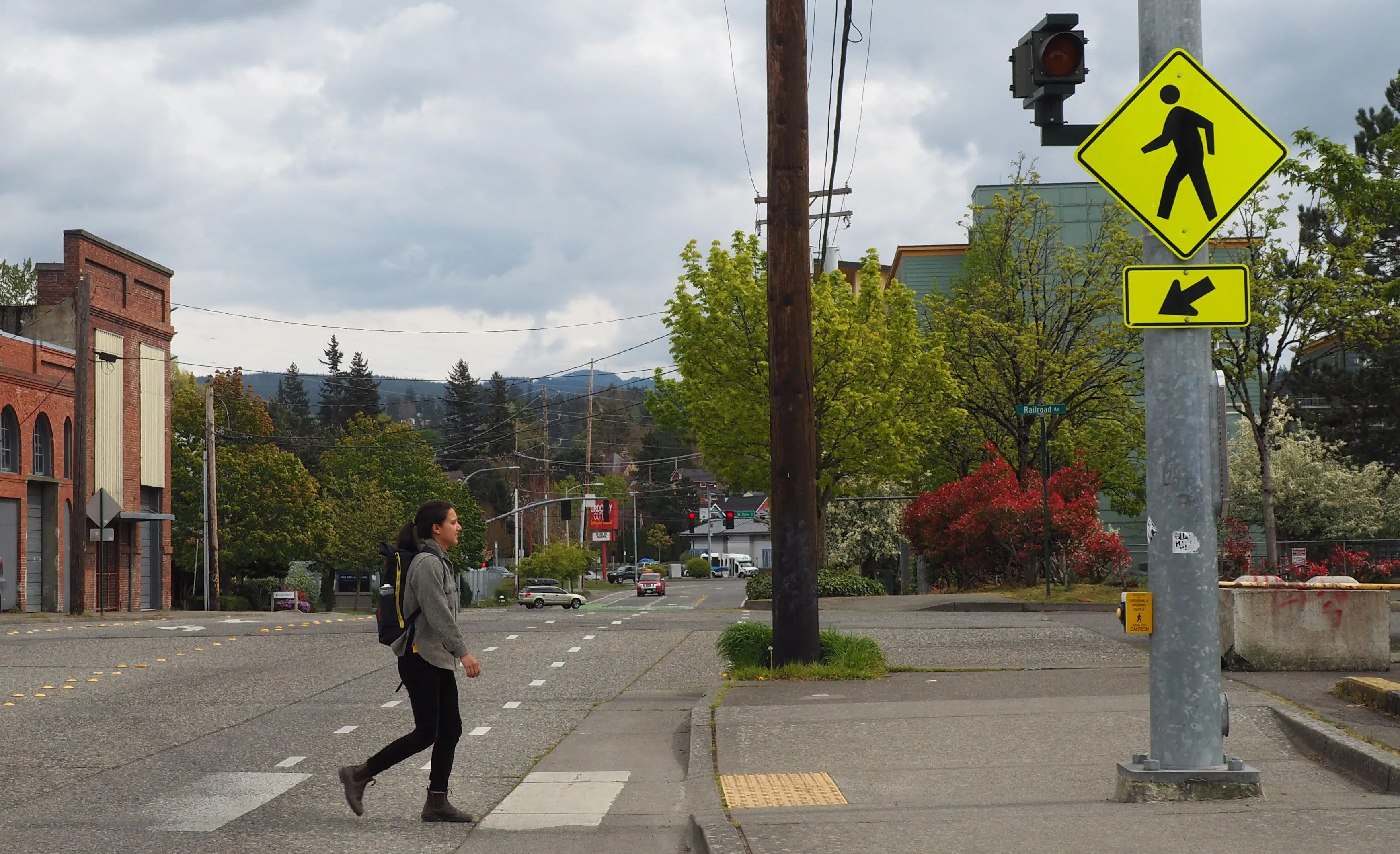 Person walking through hashed crosswalk with flashing light