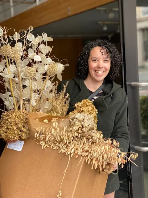Person smiling holding plants