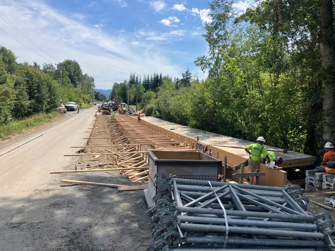 Construction workers build a path next to a road