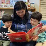 A mother reads to two children.