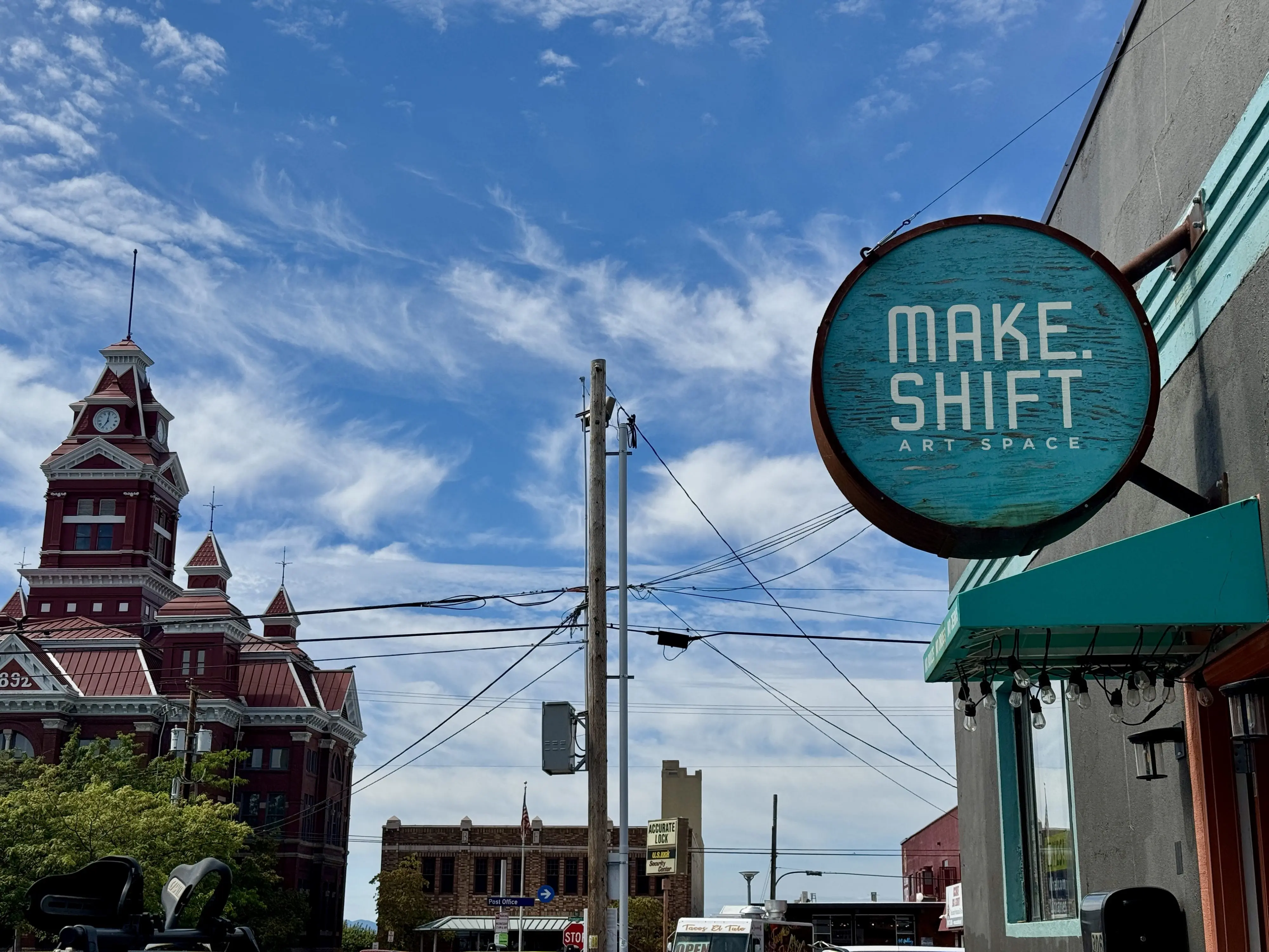 A round building sign reading "Make.Shift Art Space" with a historic building in the background