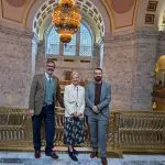 Two men and a woman in an ornate public building