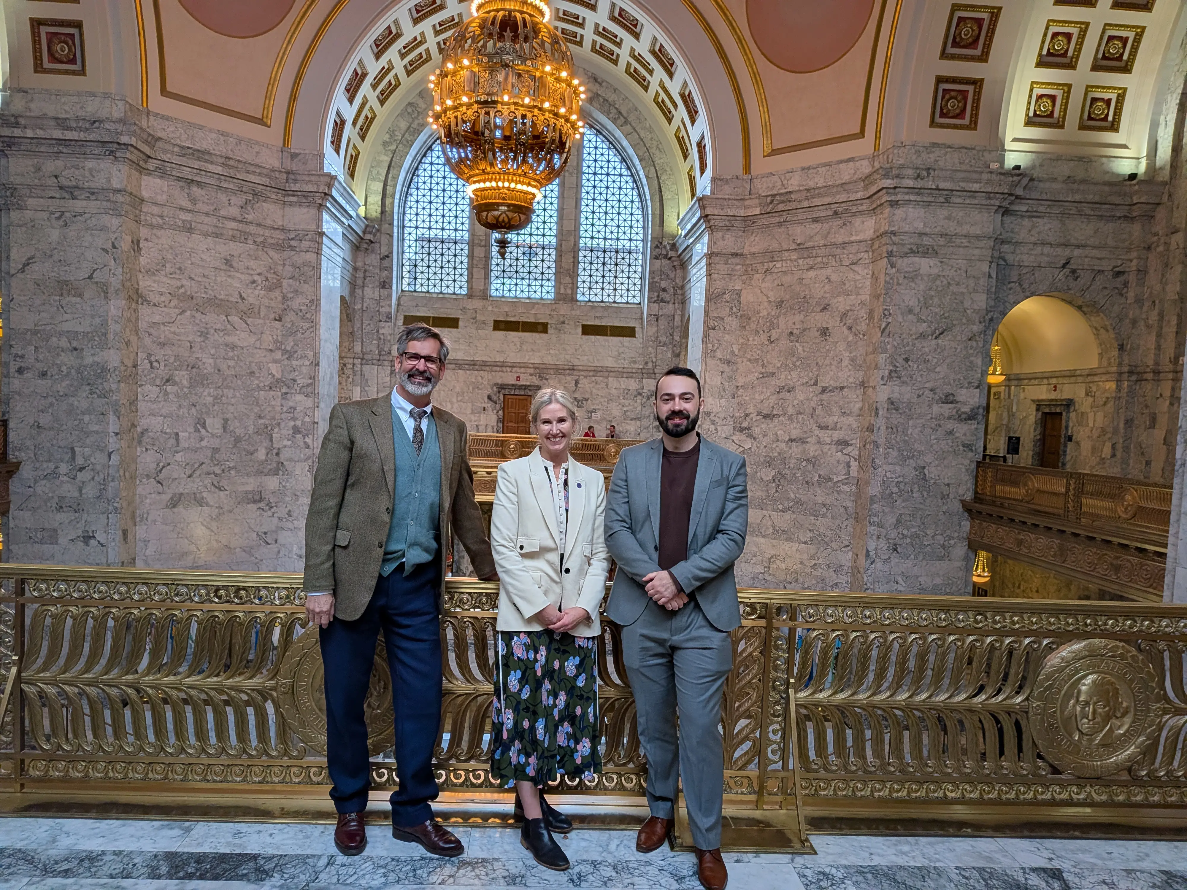 Two men and a woman in an ornate public building