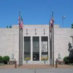 The front of City Hall with flags leading to the building.