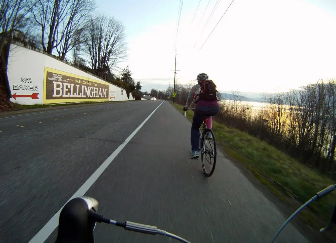 Person biking along State Street with view of Bellingham Bay