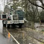 A city work truck next to a nearly overflowing creek