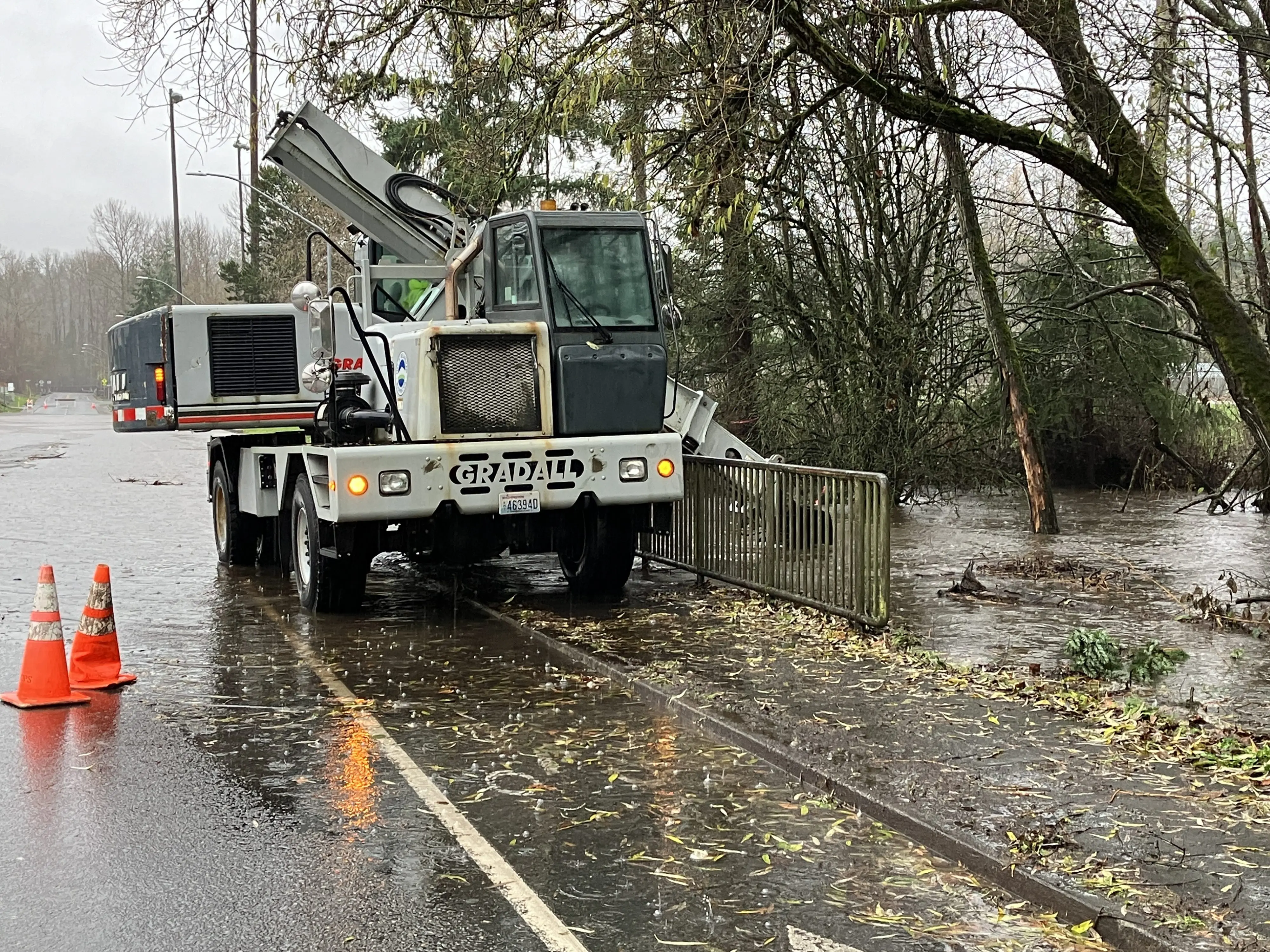 A city work truck next to a nearly overflowing creek