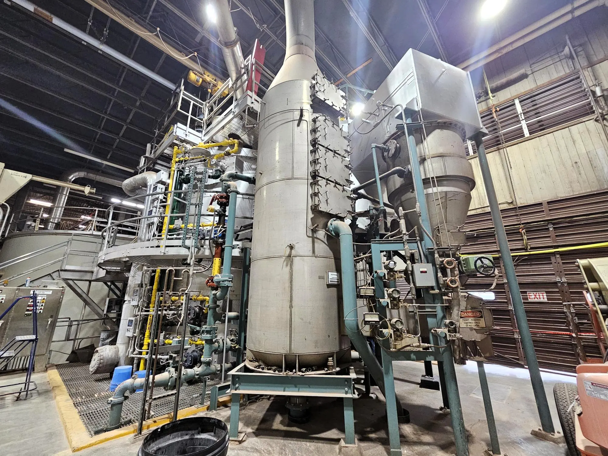 industrial containers and pipe inside a large building