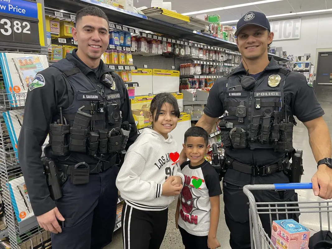 Two Bellingham Police Officers pose with kids in a store