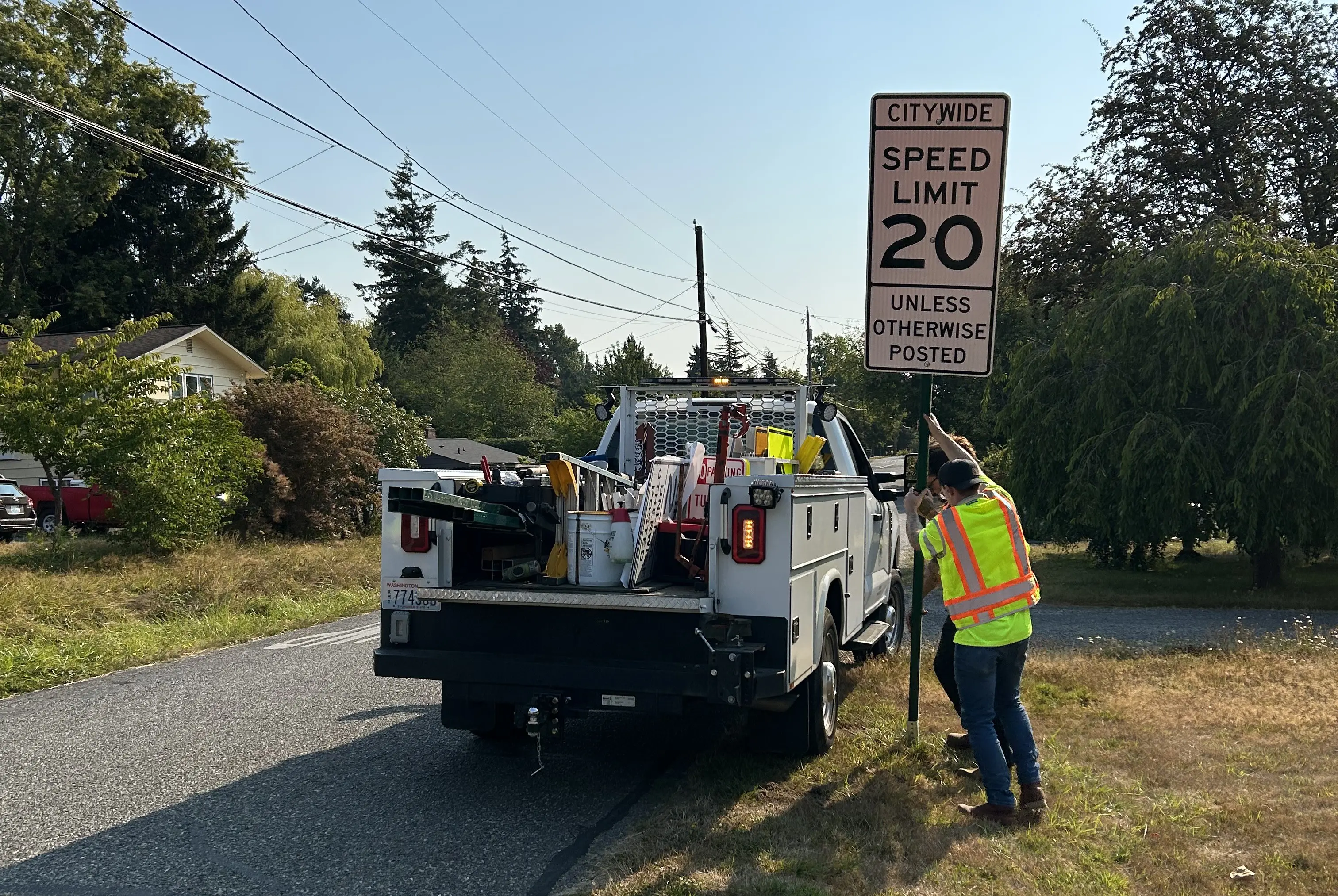 Construction workers install a roadside sign