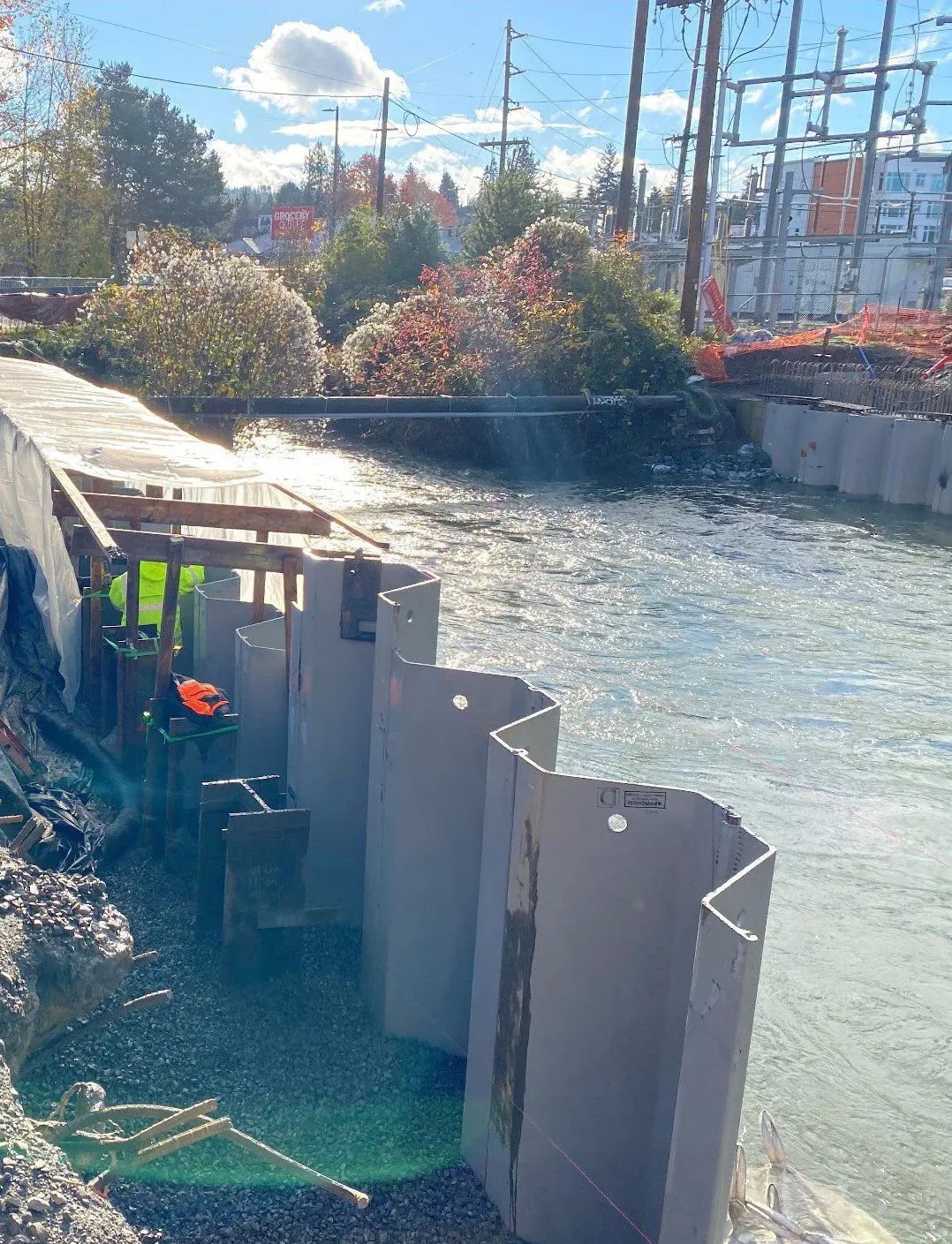 Construction workers building structure alongside creek