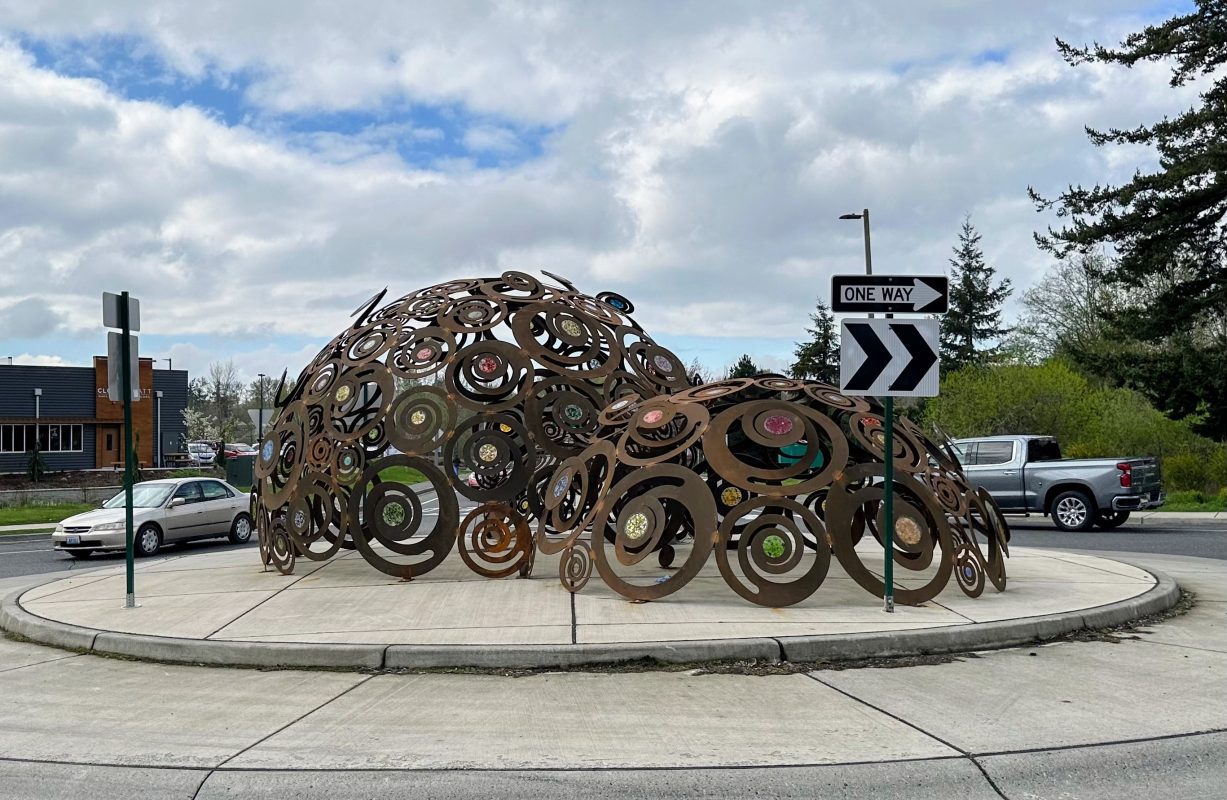 2 domed, swirly, rusty metal art features in center of roundabout