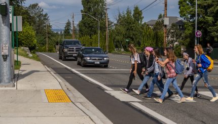 Group of school-aged girls crossing the street at a crosswalk