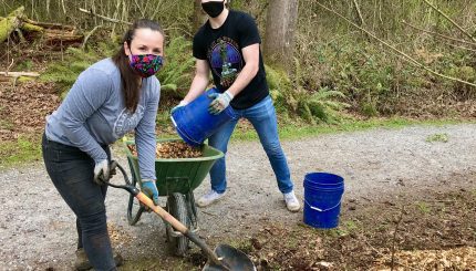 two adults volunteering by a natural trail