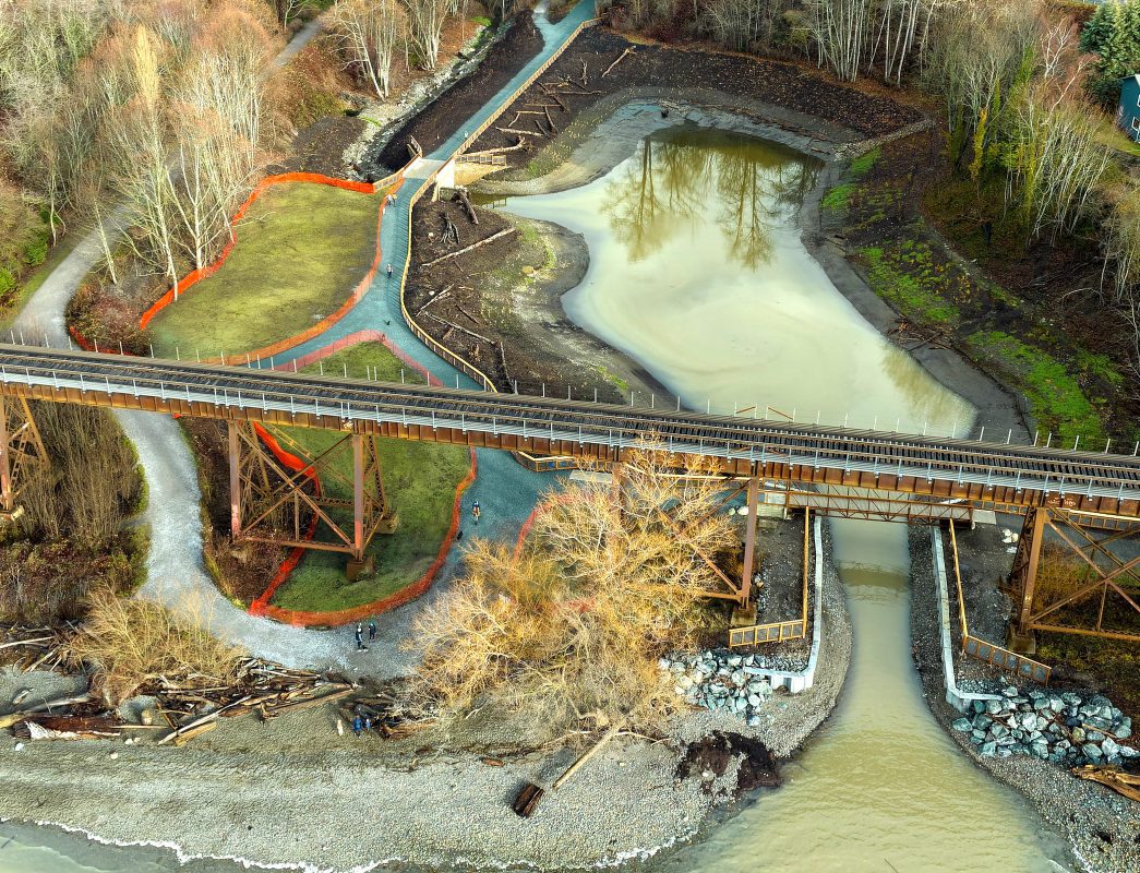 Aerial view of the estuary, with trails surrounding it and a railroad trestle above. 