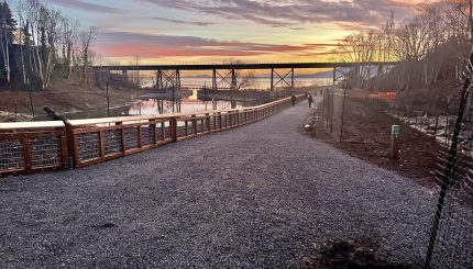 A gravel path along the Little Squalicum estuary with the sunset in the background